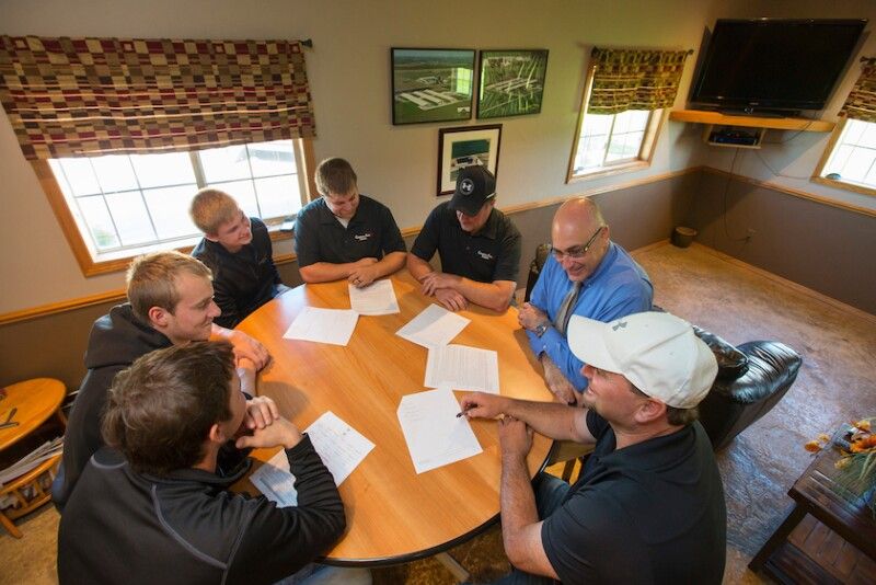 A team of farmers gathered around a table for a business meeting.