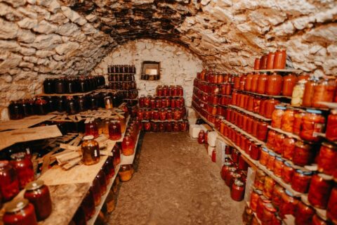 Stone cellar packed with shelves of jars of preserved vegetables
